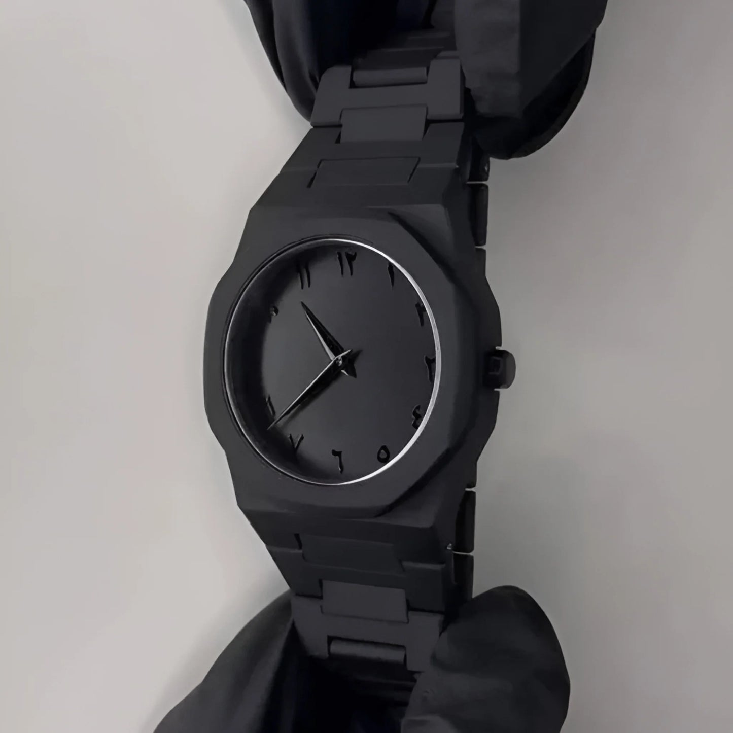 Black wristwatch on a plain background