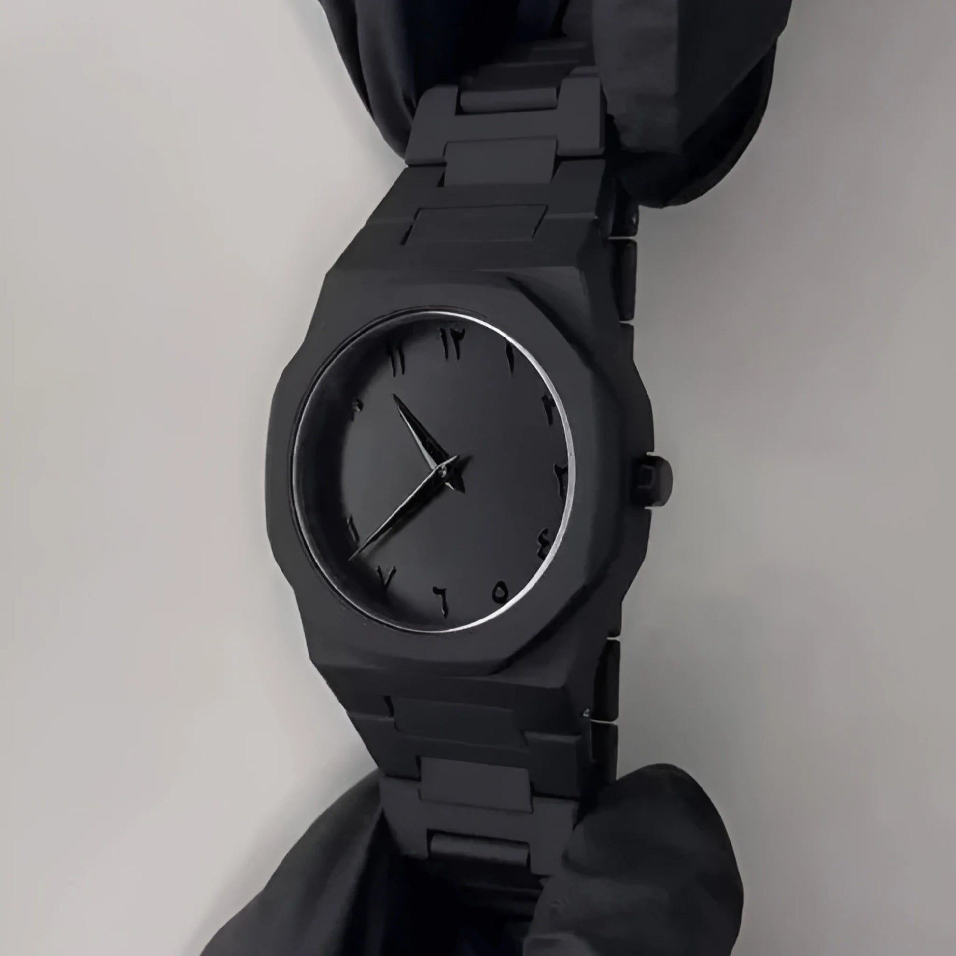 Black wristwatch on a plain background