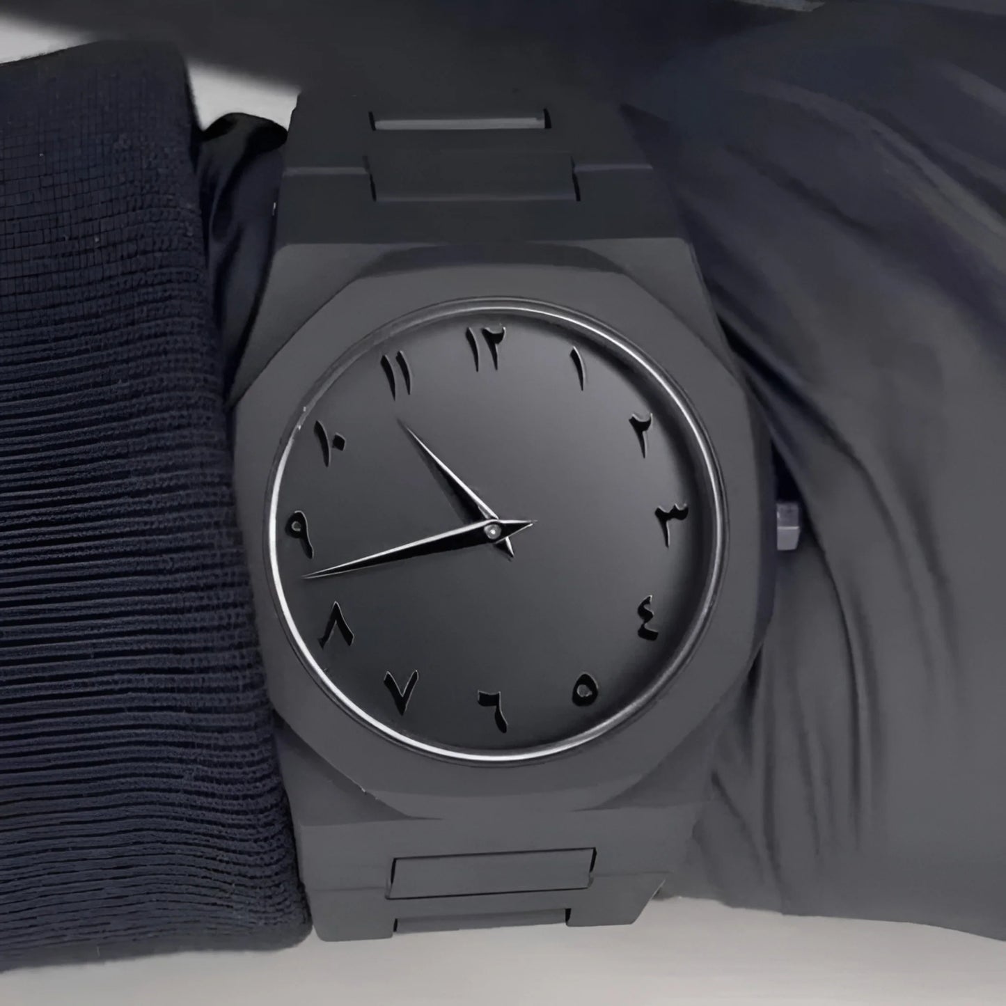Gray wristwatch on a dark fabric background