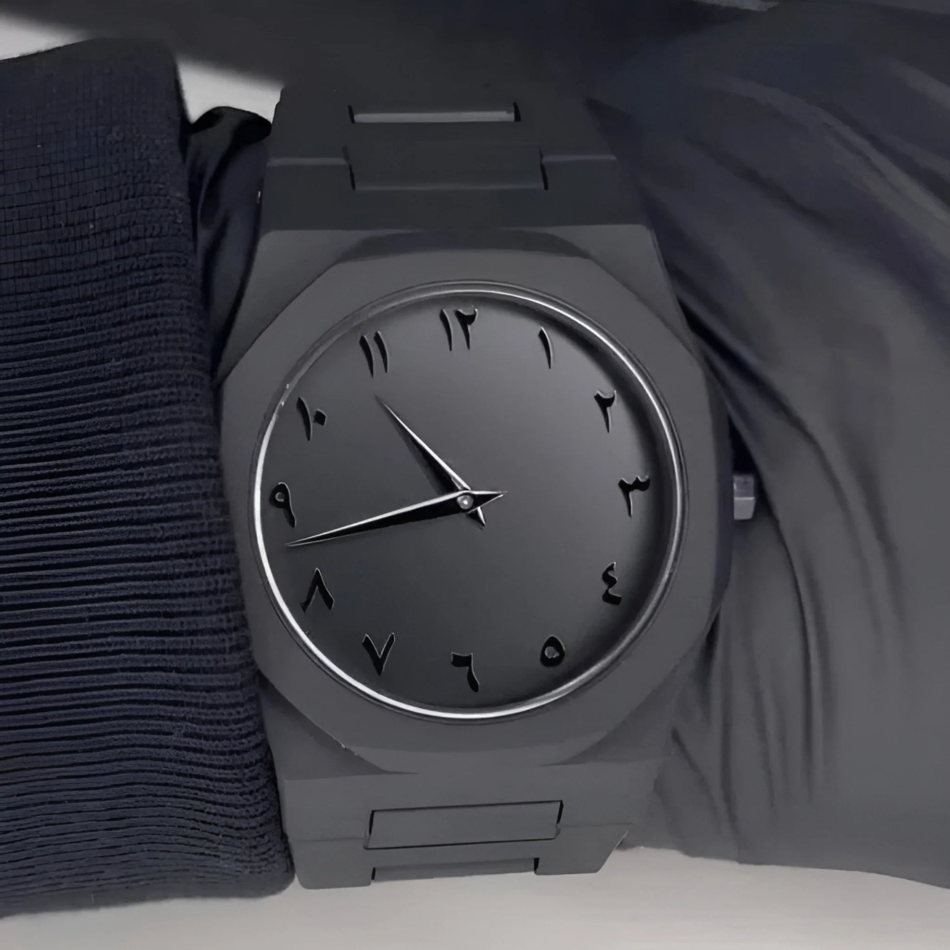 Gray wristwatch on a dark fabric background